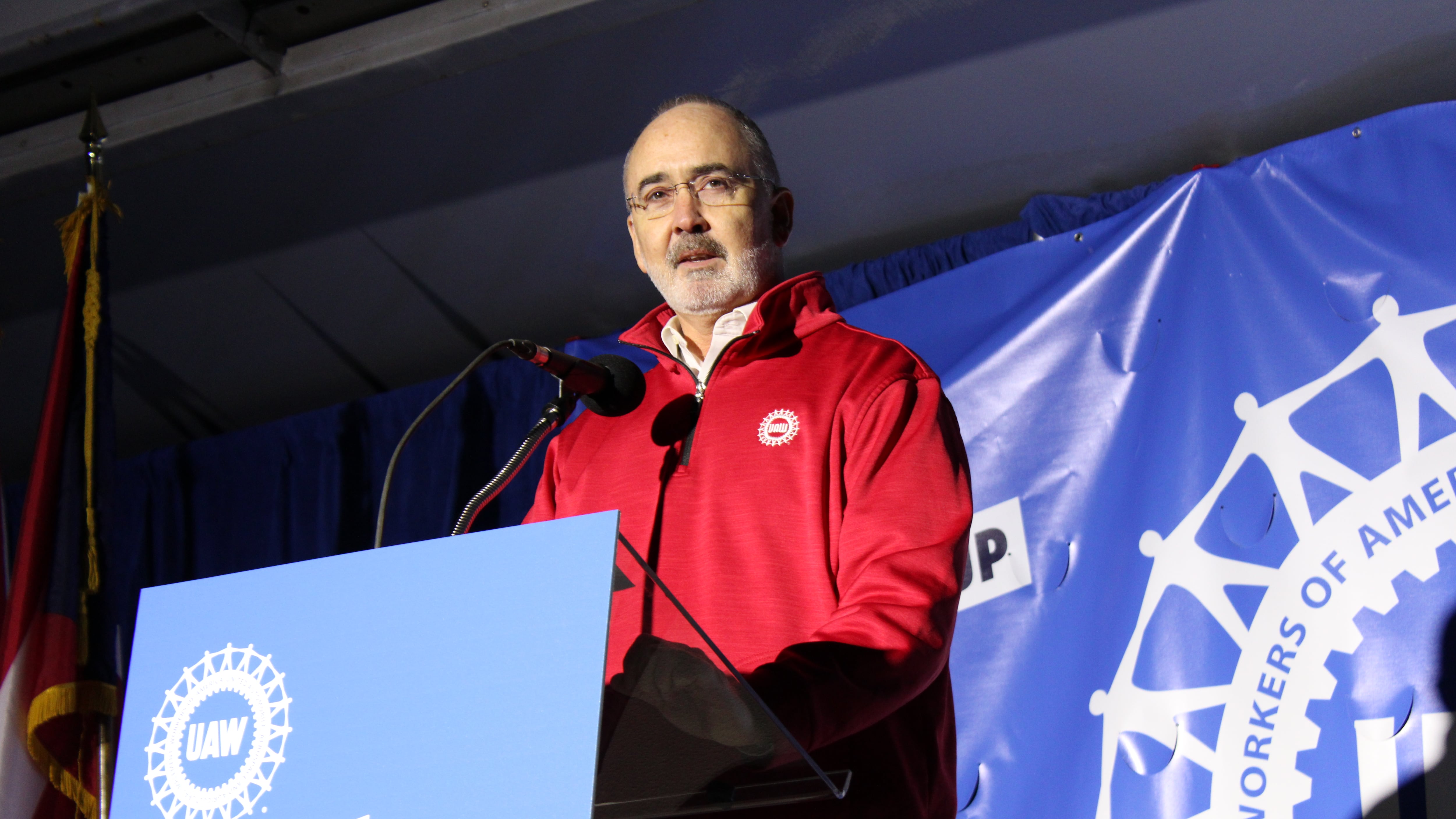 UAW President Shawn Fain stands behind a podium addressing a crowd at an election rally at the UAW's Solidarity House headquarters.